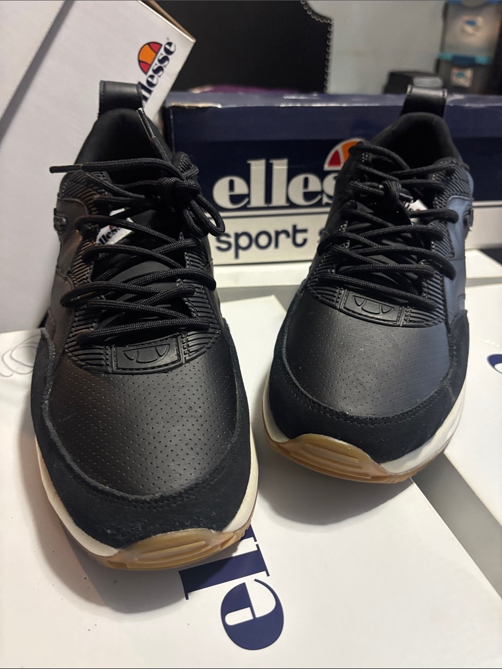 Ellesse Black Sneakers with White Midsole and Red Heel Accent.